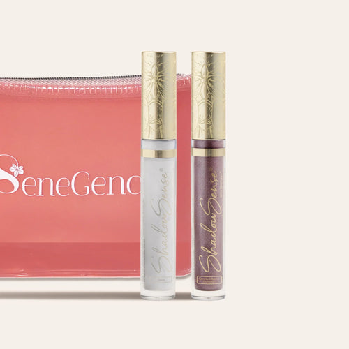 ShadowSense eyeshadow duo in clear tubes with gold ornate caps beside a pink zip pouch