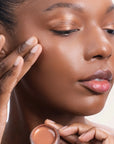 Model applying Bouncy Mousse Multi-Use Pigment product shade Bronze Bliss.