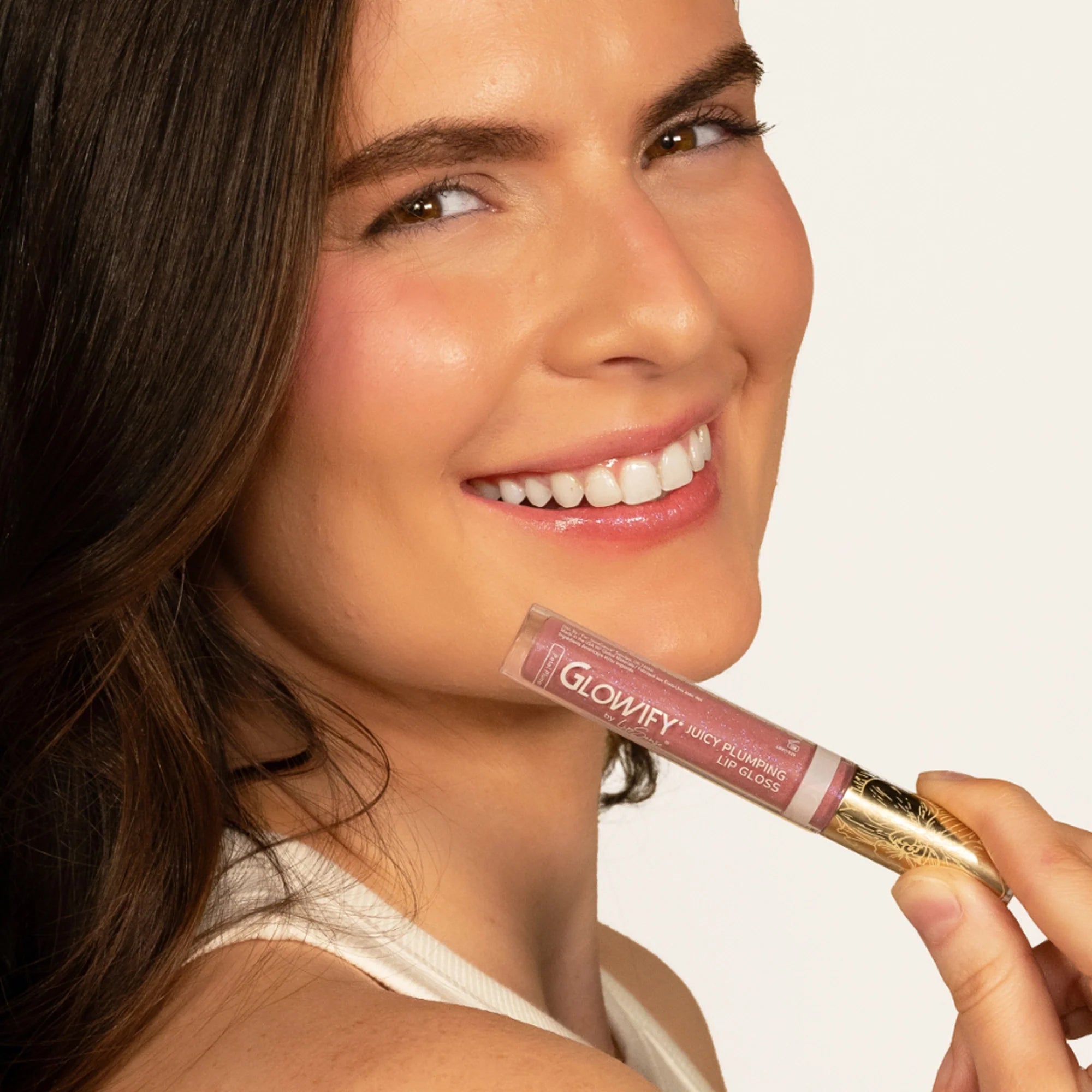 Model wearing Glowify Juicy Plumping Lip Gloss product shade Petal Plump.
