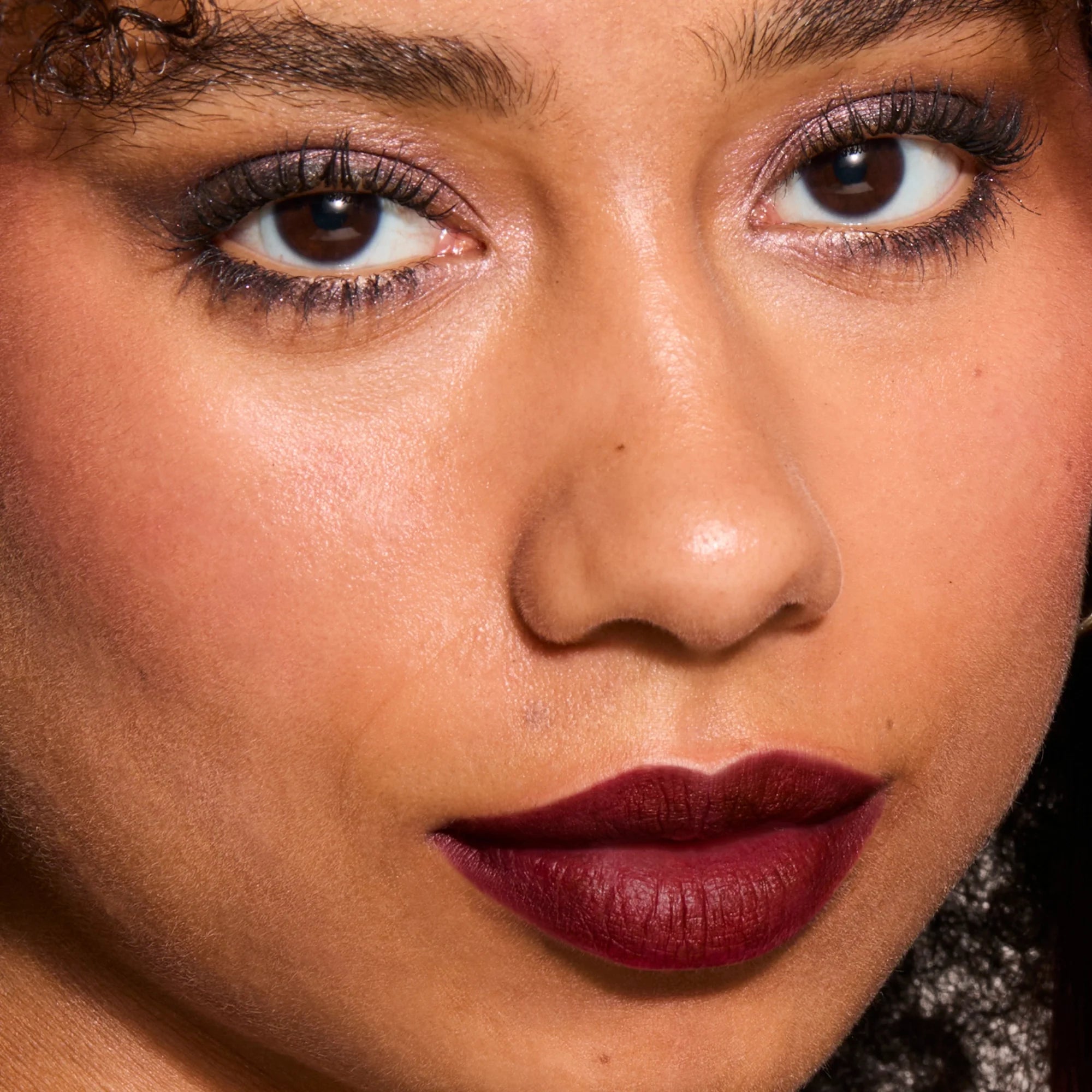 Model wearing LipSense Cream product shade Burgundy Plum.