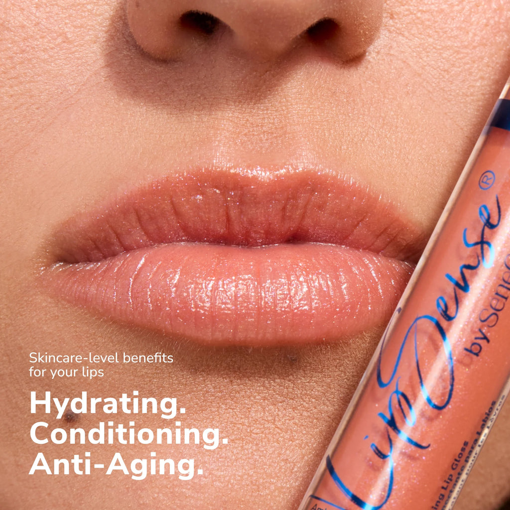 Close up of glossy lips with a LipSense gloss tube beside them showing a peachy shade