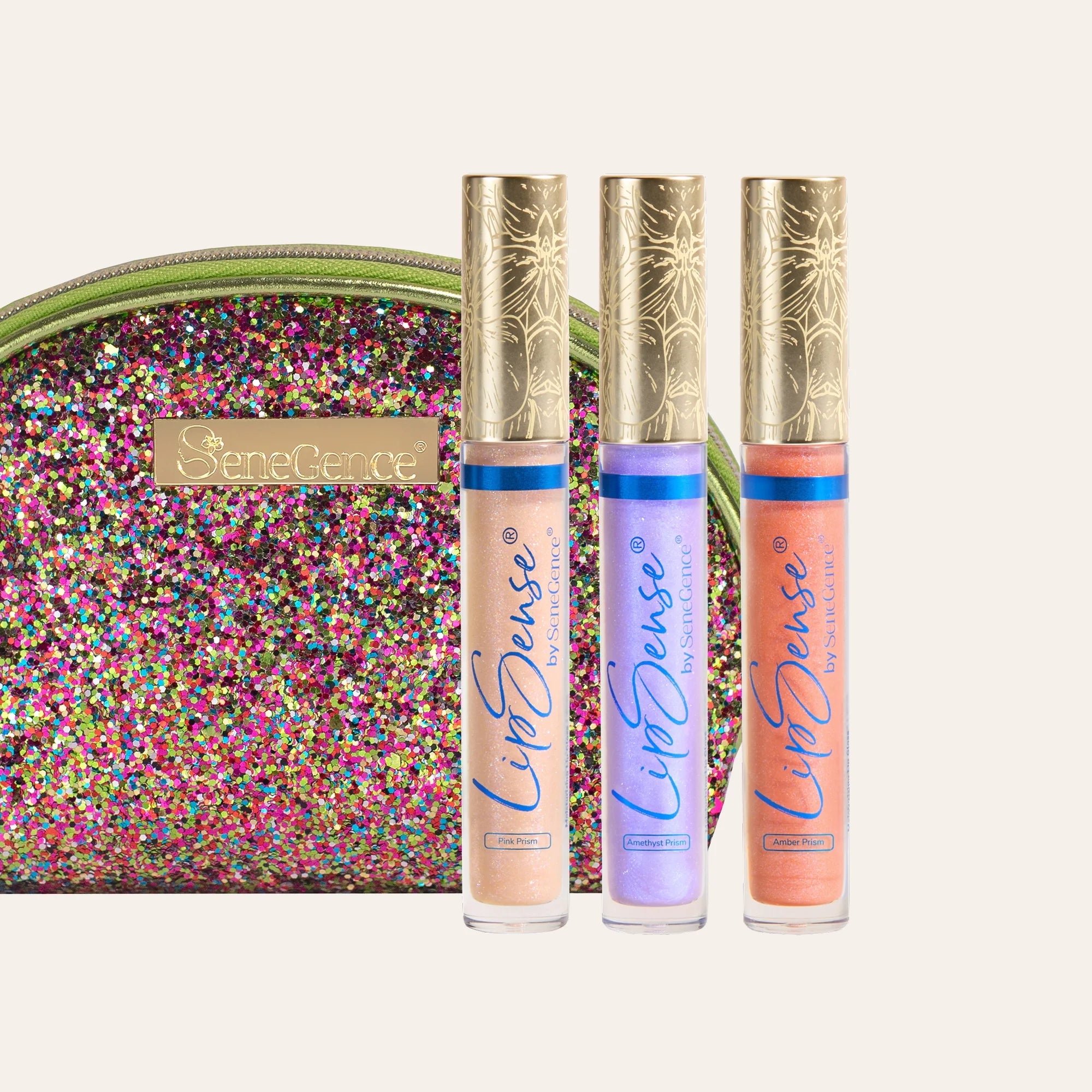 Three LipSense gloss tubes with ornate gold caps in front of a multicolored glitter clutch
